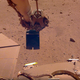 InSight’s robotic arm attempting to remove dust from the solar panel by sprinkling sand in the wind.